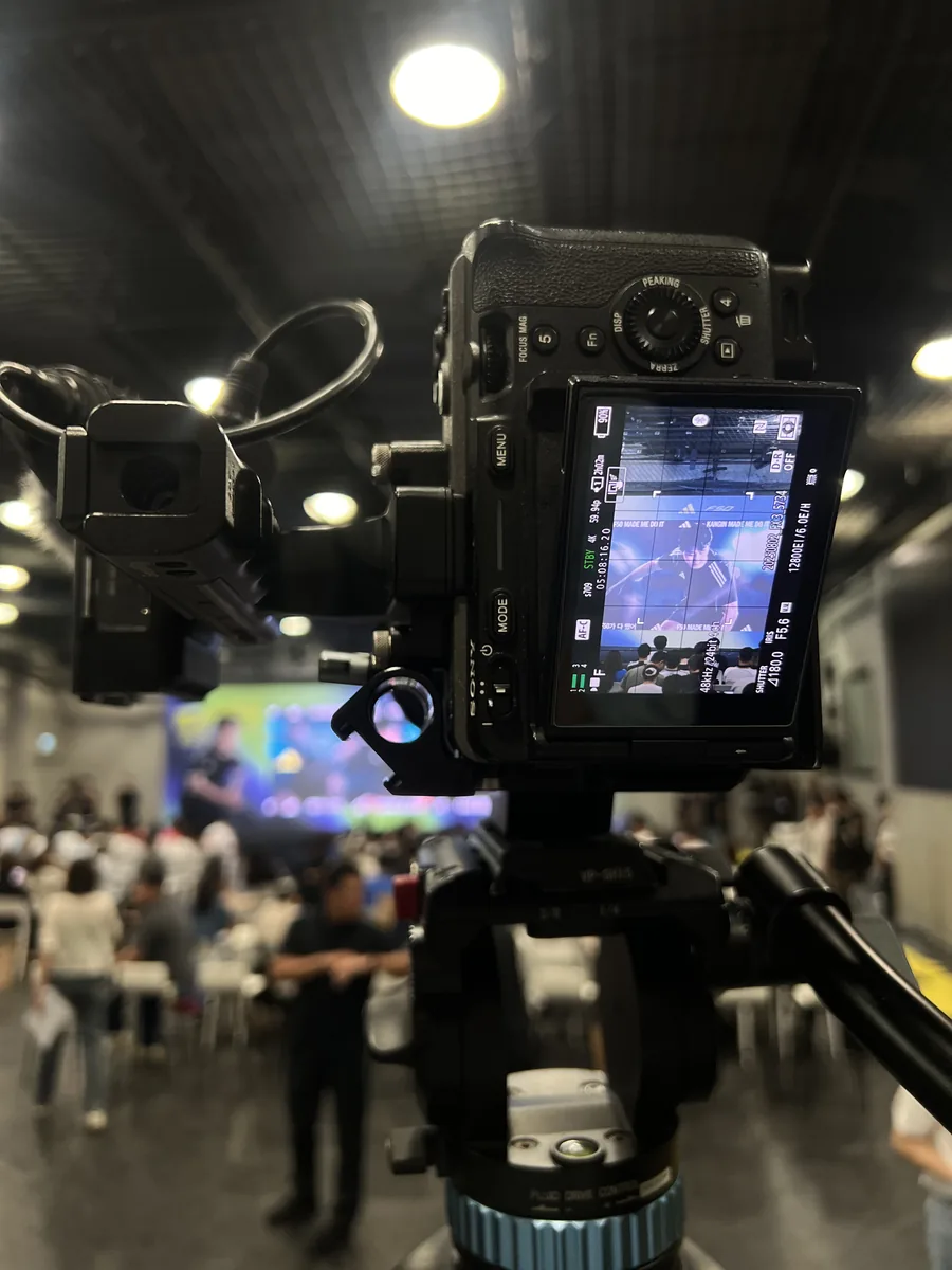 Camera on a tripod recording an indoor event