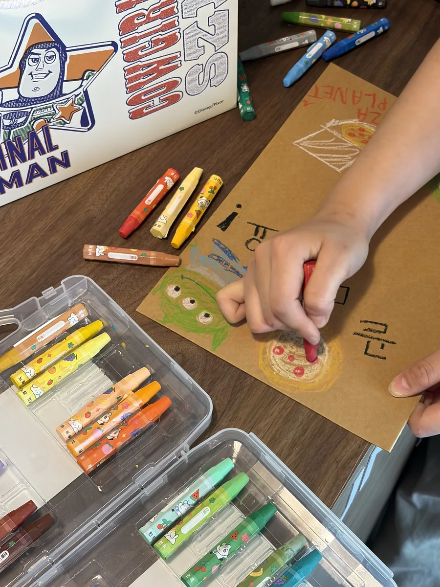 Coloring a Toy Story sheet with crayons